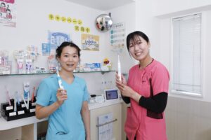 電動歯ブラシを持つ松友歯科スタッフ